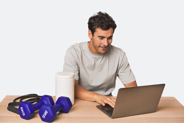 Photo hispanic male trainer with laptop planning workouts