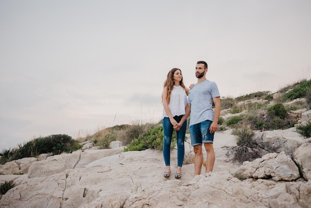 A Hispanic man is holding the hand of his Latina girlfriend in Spain