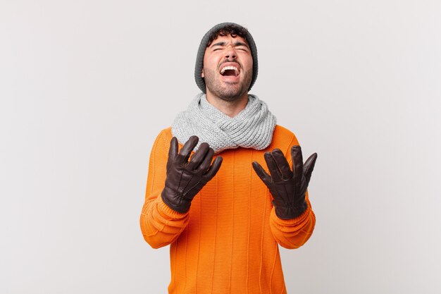 Hispanic man looking desperate and frustrated, stressed, unhappy and annoyed, shouting and screaming