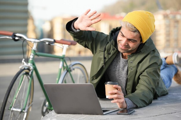 自転車の横で屋外でビデオ会議をしているヒスパニック系の男性