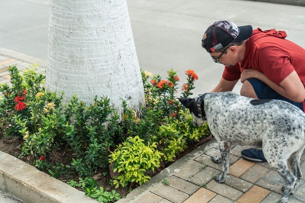 Hispanic Man Playing Outdoor With Her Dog