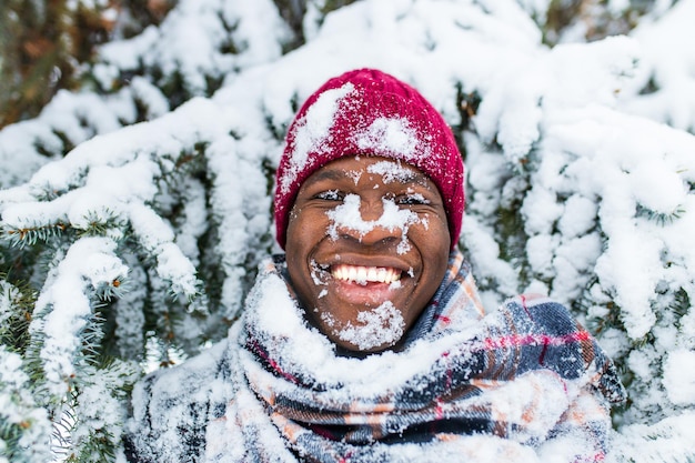 Hispanic man in red hat with snowflake on face having fun and feeling christmas mood in park