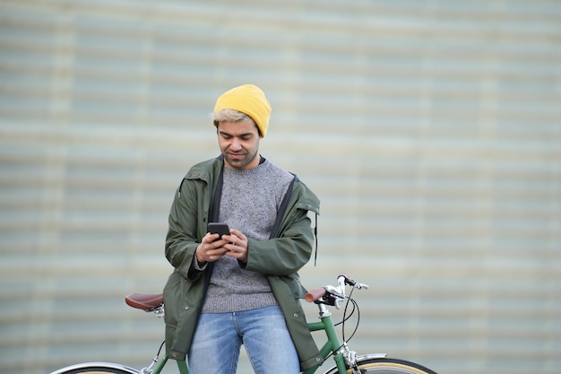 自転車で休んでいる間電話を使用してヒスパニック系の男性