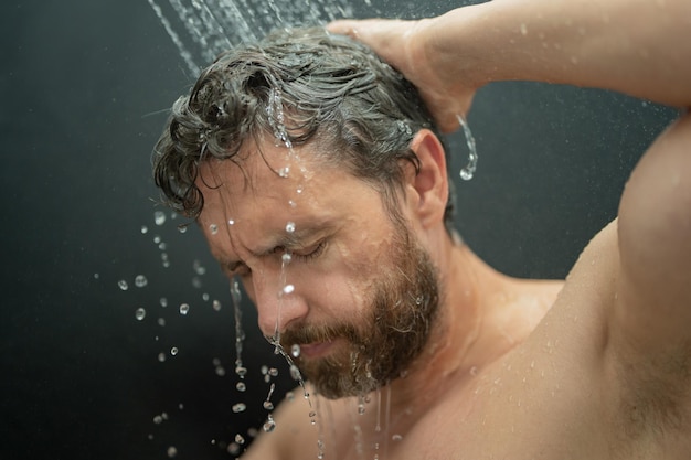 Photo hispanic man washing hair in bathroom guy bathing shower head in bathtub male face in shower man tak