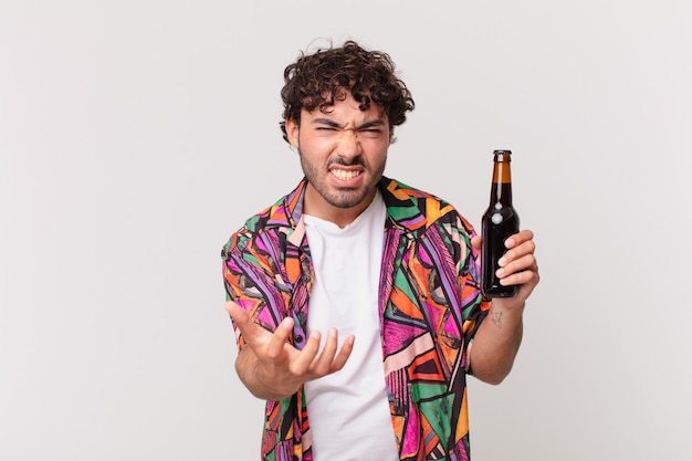 Hispanic man with beer looking angry, annoyed and frustrated screaming wtf or whatÃ¢ÂÂs wrong with you