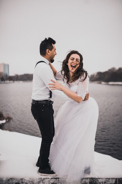 Hispanic man and woman are groom and bride in winter in snow