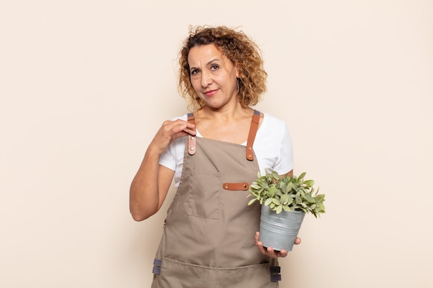 Hispanic middle age woman looking arrogant, successful, positive and proud, pointing to self