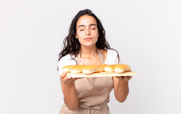 Hispanic pretty chef woman holding a bread buns troy