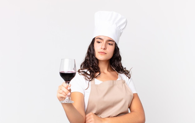 Hispanic pretty chef woman holding a glass of wine