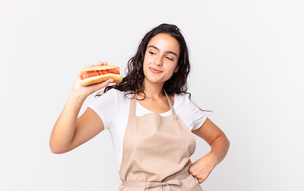 Hispanic pretty chef woman holding a hot dog