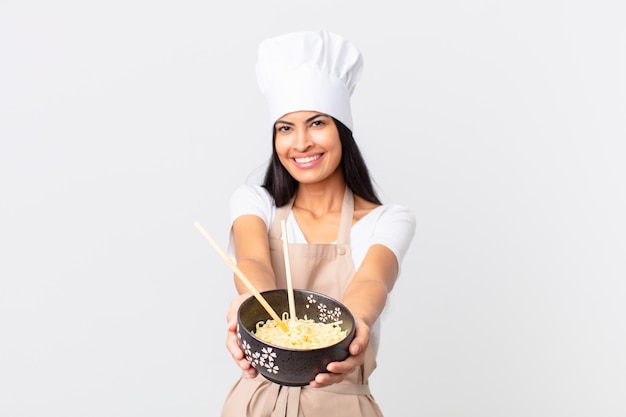 Hispanic pretty chef woman holding a noodles bowl