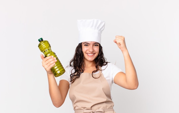 Hispanic pretty chef woman holding an olive oil bottle