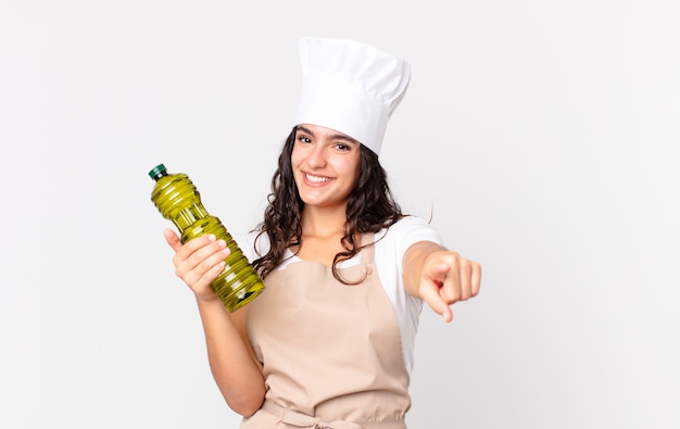 Hispanic pretty chef woman holding an olive oil bottle