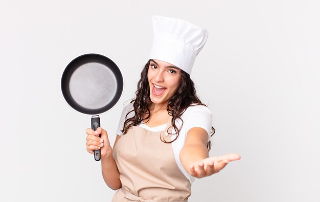 Hispanic pretty chef woman holding a pan