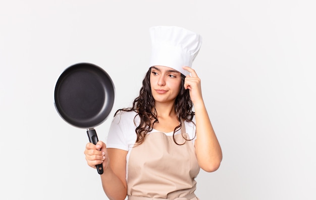 Испаноязычное довольно шеф-повар женщина держит сковороду