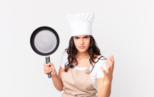 Hispanic pretty chef woman holding a pan