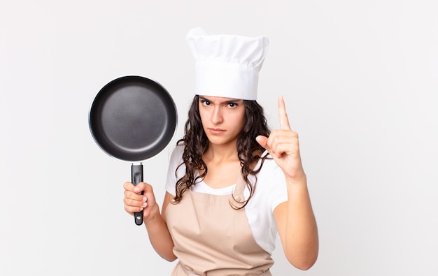 Hispanic pretty chef woman holding a pan