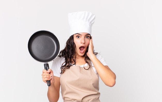 Hispanic pretty chef woman holding a pan