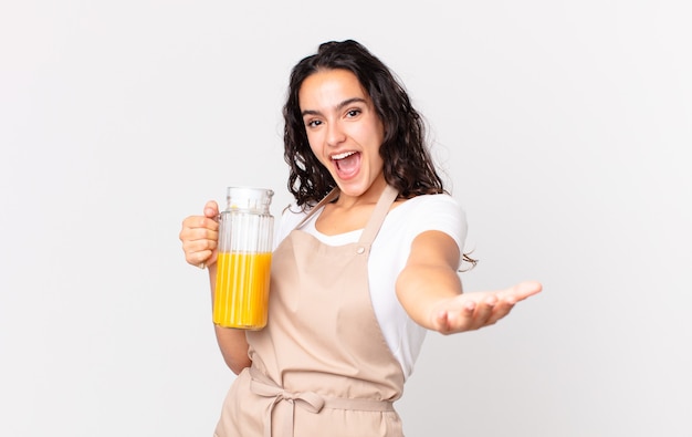 Donna ispanica graziosa chef che prepara un succo d'arancia