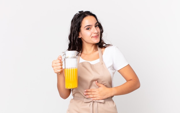 Hispanic pretty chef woman preparing an orange juice