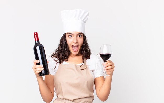 Hispanic pretty chef woman with a bottle of wine