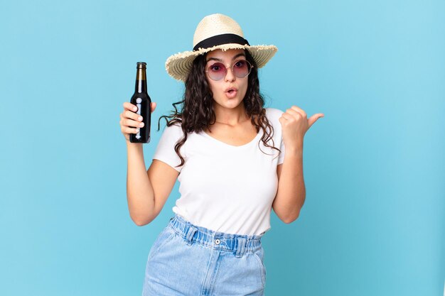 Hispanic pretty traveler woman with a bottle of beer