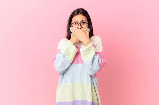 Hispanic pretty woman covering mouth with hands with a shocked