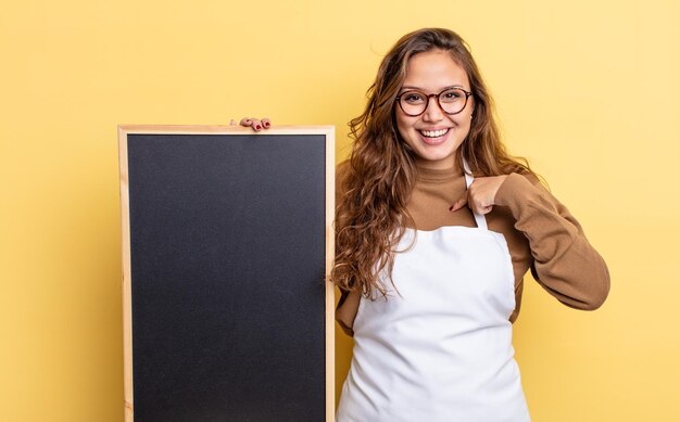 Foto bella donna ispanica che si sente felice e indica se stessa con un'eccitazione. concetto di spazio copia lavagna