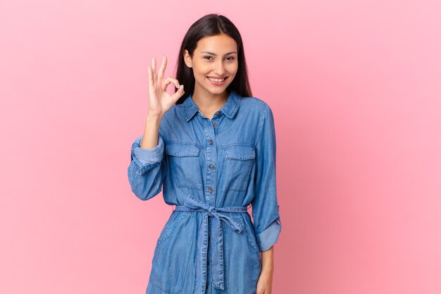 Hispanic pretty woman feeling happy, showing approval with okay gesture