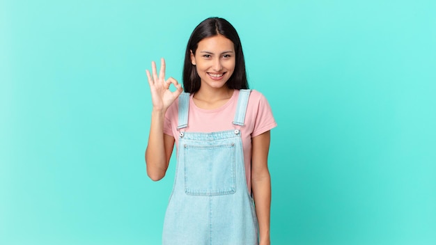 Hispanic pretty woman feeling happy, showing approval with okay gesture