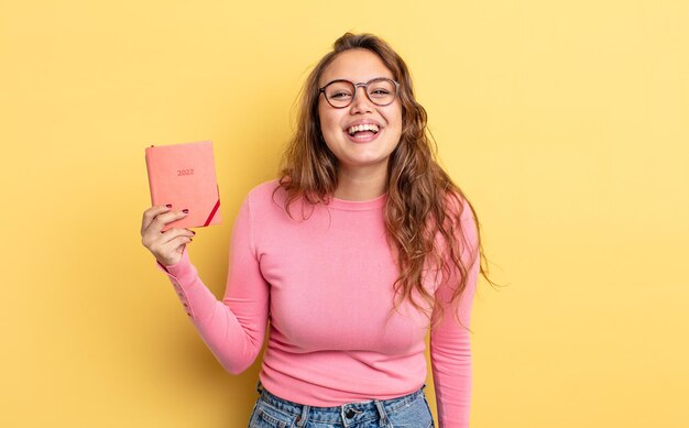 Hispanic pretty woman looking happy and pleasantly surprised. agenda concept