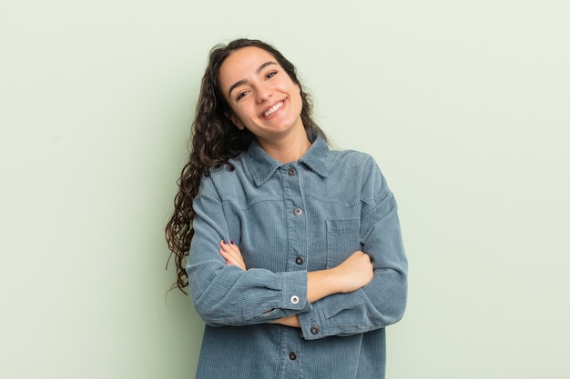 Hispanic pretty woman looking like a happy proud and satisfied achiever smiling with arms crossed