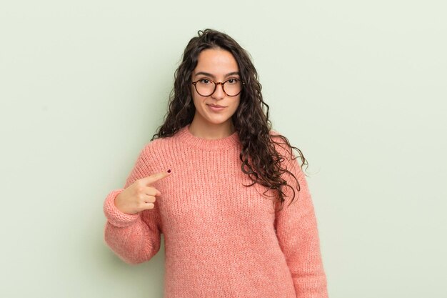 Hispanic pretty woman looking proud confident and happy smiling and pointing to self or making number one sign