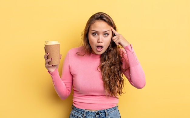 Foto bella donna ispanica che sembra sorpresa, realizzando un nuovo pensiero, idea o concetto. portare via il concetto di caffè