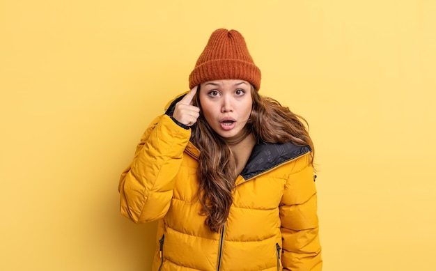 Hispanic pretty woman looking surprised realizing a new thought idea or concept winter clothes