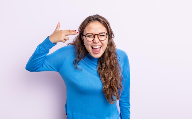 Hispanic pretty woman looking unhappy and stressed suicide gesture making gun sign with hand pointing to head