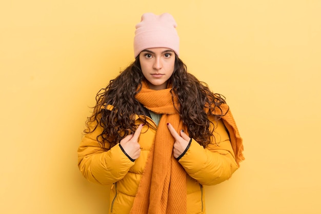 Foto bella donna ispanica che indica se stessa con uno sguardo confuso e interrogativo, scioccata e sorpresa di essere stata scelta