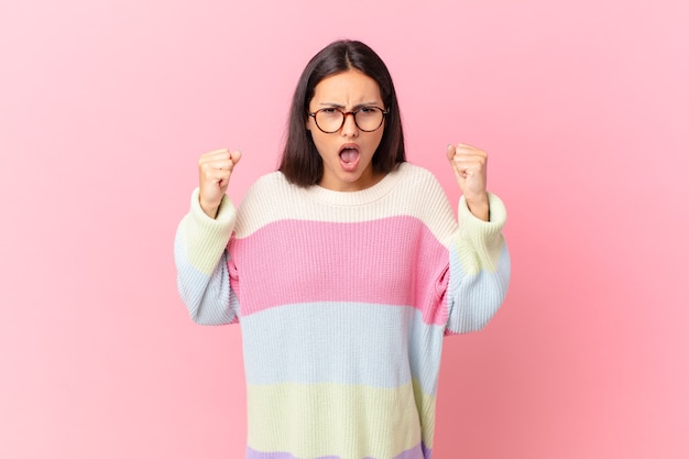 Hispanic pretty woman shouting aggressively with an angry expression