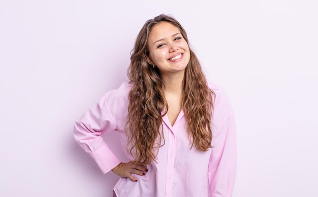 Hispanic pretty woman smiling happily with a hand on hip and confident, positive, proud and friendly attitude