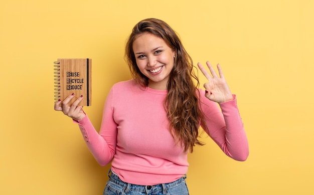 Hispanic pretty woman smiling and looking friendly, showing number three. recycle concept