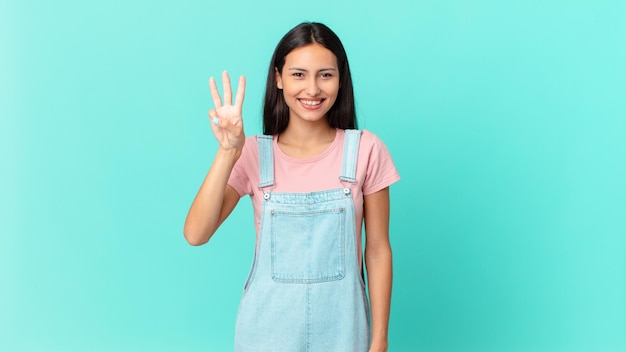 Hispanic pretty woman smiling and looking friendly, showing number three