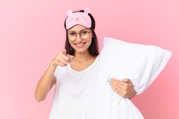 Hispanic pretty woman wearing pajamas and holding a pillow