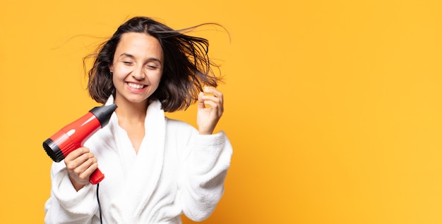 写真 ヘアドライヤーを持つヒスパニック系のきれいな女性