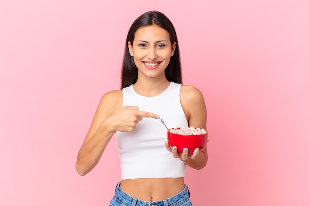 Hispanic pretty woman with a breakfast bowl with flakes