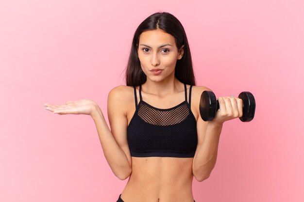 Hispanic pretty woman with a dumbbell. fitness concept