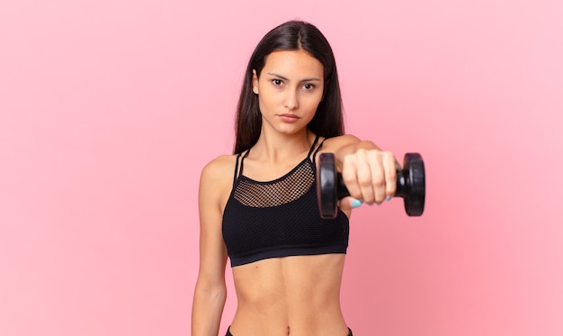 Hispanic pretty woman with a dumbbell. fitness concept