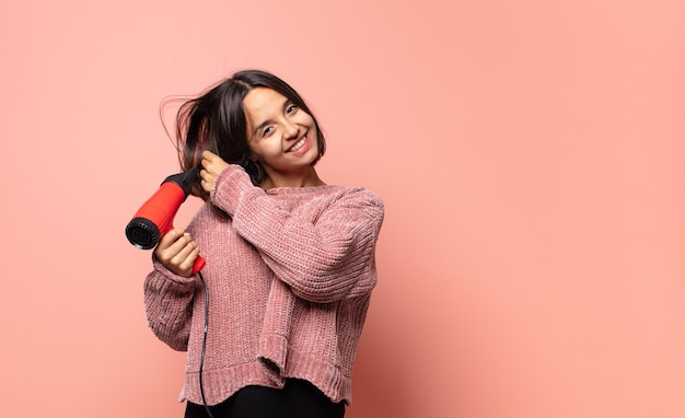 Hispanic pretty woman with a hair dryer