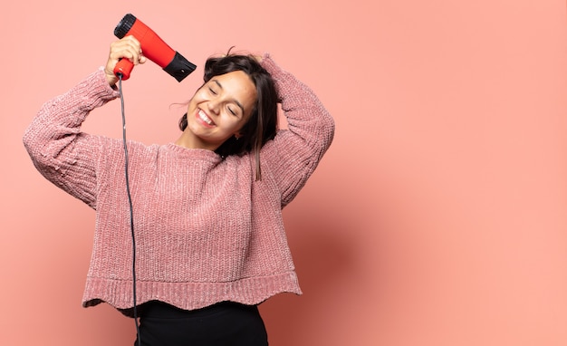 Hispanic pretty woman with a hair dryer