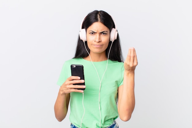 Hispanic pretty woman with headphones and a smarphone