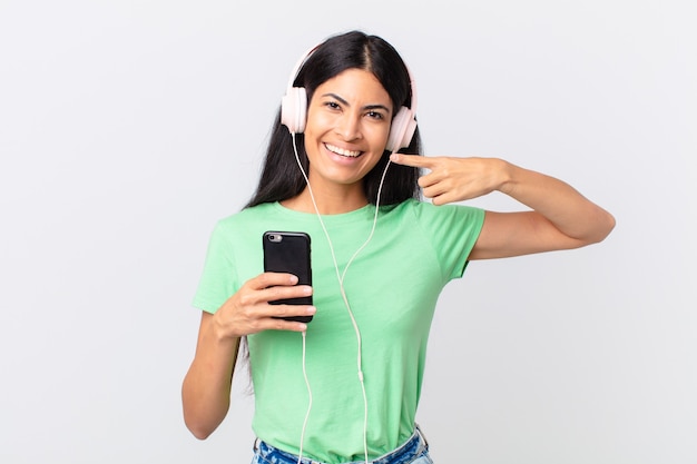 Hispanic pretty woman with headphones and a smarphone